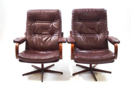 A pair of 20th century Danish style leather and simulated rosewood armchairs