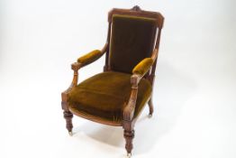 A Victorian walnut armchair on heavily carved supports,