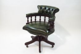 A 20th century green leather swivel Captain's chair with button back,