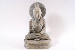 A carved grey/green hardstone figure of a Thai deity seated in the lotus position,
