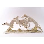 A large Hutschenreuther porcelain figure group of three greyhounds in running pose by H Achtziger,
