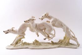 A large Hutschenreuther porcelain figure group of three greyhounds in running pose by H Achtziger,