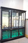 An Edwardian ebonised triple display cabinet by Vale brothers of Weston-Super-Mare,