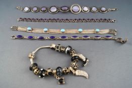 A selection of five bracelets consisting of four sterling silver gemset linked bracelets and a