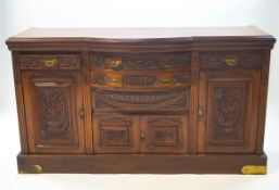 An Edwardian mahogany sideboard with carved floral decoration, three drawers over a cupboard base,