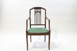 An Edwardian mahogany elbow chair with five straight slats and carved swag detail,