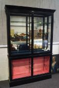 An Edwardian ebonised two door display cabinet by Vale Brothers of Weston-super-Mare,