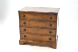 A George III style walnut veneered chest of four drawers,