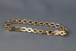 A yellow and white gold linked bracelet, trigger clasp. hallmarked 9ct gold, London. 7.