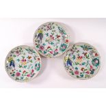 A set of three Canton porcelain saucer dishes, decorated in polychrome enamels with butterflies,