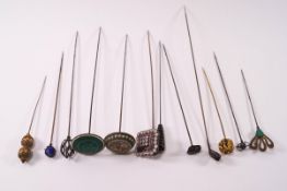 A collection of twelve hat pins including a silver golf club,