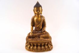 A 19th century gilt metal Buddha figure seated on a double lotus,