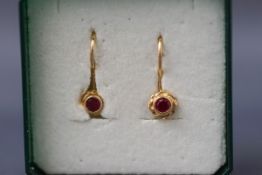 A yellow gold pair of single stone earrings having continental hook fittings.