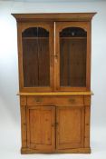 A Victorian pine dresser with two glazed doors above one drawer and two panelled doors on plinth