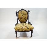 A Victorian ebonised nursing chair on turned supports,