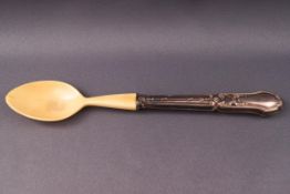 An early 20th Christening spoon with embossed white metal handle and ivory bowl,
