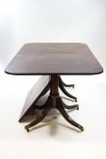 A Regency style mahogany dining table with each twin pedestal on turned support with four splayed