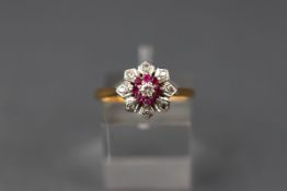 A yellow and white gold cluster ring set with eight round rubies and nine diamonds. Yellow shank.