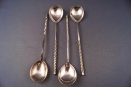 A set of four Russian white metal spoons with spirally fluted handles and engraved bowls,