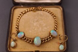A 15ct gold curb link bracelet set with three cabochon oval opals of fine quality together with a