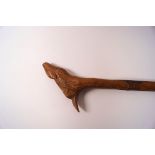 A wooden walking stick with carved shaft and the knop as a deer