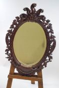 A late Victorian carved mahogany wall mirror with bevelled glass,