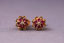 A pair of 9ct gold, ruby and diamond cluster stud earrings. Weight: 1.