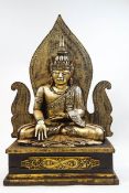 A large giltwood carved figure of a seated Thai deity,