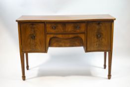 An Edwardian mahogany serpentine sideboard, two central drawers flanked by cuboards,