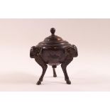 A 19th century bronze Classical inkwell and cover, the three feet as rams heads and legs,