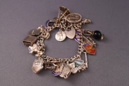 A white metal curb bracelet with padlock and safety chain fitted with an assortment of twenty one