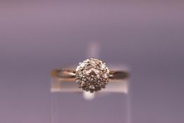 A yellow and white metal cluster ring set with diamonds. Hallmarked 18ct, Birmingham.