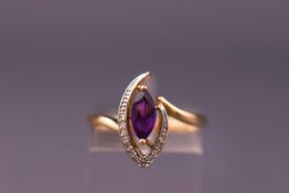 A yellow metal dress ring set with a marquise cut amethyst and diamonds.
