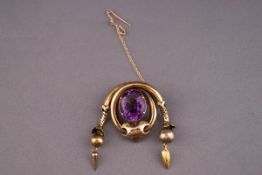 A Victorian yellow metal and amethyst brooch. Pin and hook fitting with additional safety chain.