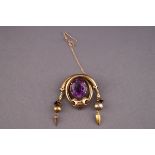 A Victorian yellow metal and amethyst brooch. Pin and hook fitting with additional safety chain.