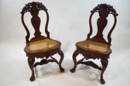 A pair of 19th century Indian hardwood chairs with cane seats,