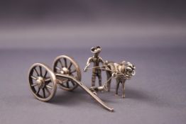 An early 20th century Dutch white metal model of a horse and handler pulling a carriage,