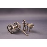 An early 20th century Dutch white metal model of a horse and handler pulling a carriage,