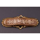 A rectangular bar cameo brooch with flowers. tests indicate 9ct gold. Weight: 10.