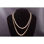 Two strands of graduated cultured pearl necklaces each having silver clasps set with