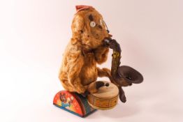 A Cragstan early battery operated monkey, banging a drum and blowing a saxophone,