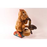 A Cragstan early battery operated monkey, banging a drum and blowing a saxophone,