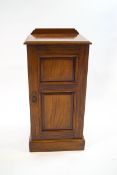 A Victorian mahogany pot cupboard, the panelled door enclosing a single shelf,