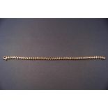 A modern yellow metal tennis bracelet set with forty eight round diamonds measuring 2.