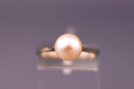 A white metal single stone ring set with a 8.00mm cultured pearl. Stamped 750. Size: N 1/2.