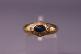 A yellow metal dress ring set with sapphire, aquamarine and diamonds. Hallmarked 9ct gold. Size L.