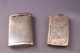 A silver vesta case in the form of a book, with hinged cover engraved scrolling foliage, 5.