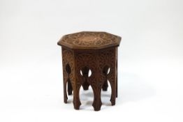 A carved mahogany octagonal occasional table with Middle Eastern inspired base,