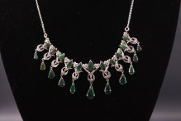 A white metal centrepiece necklace set with pear cut emeralds and single cut diamonds.