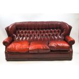 A red leather button back three seat sofa 187cm wide x 85cm deep
